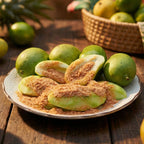 Mangoes with Mai-o-Mailee's fruit chili powder topping on a plate, surrounded by more mangoes on a wooden surface.